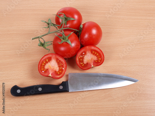 Kitchen knife and tomato on wooden table