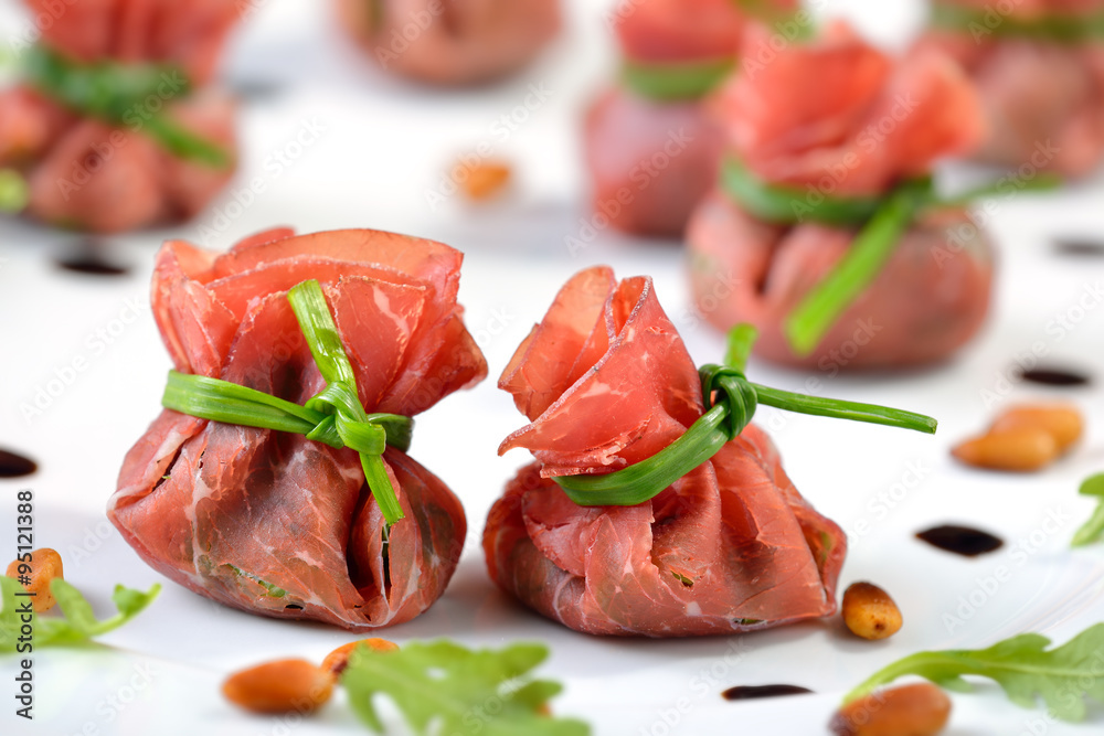 Leckere Schinkensäckchen aus Bresaola, gefüllt mit Rucola, gerösteten Pinienkernen, Parmesan und Crema di Balsamico Leckere Schinkensäckchen aus Bresaola, gefüllt mit Rucola, gerösteten Pinienkernen, Parmesan und Crema di Balsamico