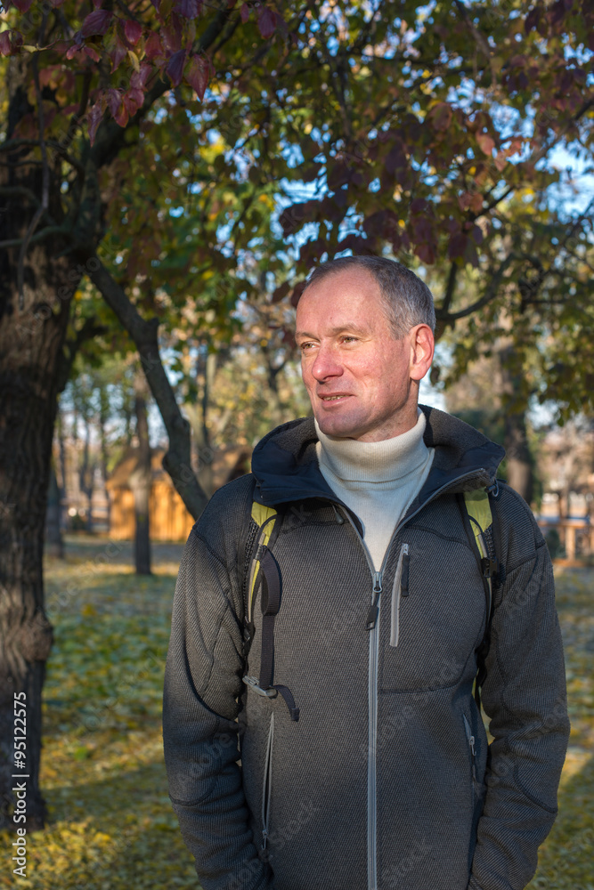 Attractive man with backpack smiling, relaxing, enjoying life in Attractive man with backpack smiling, relaxing, enjoying life in