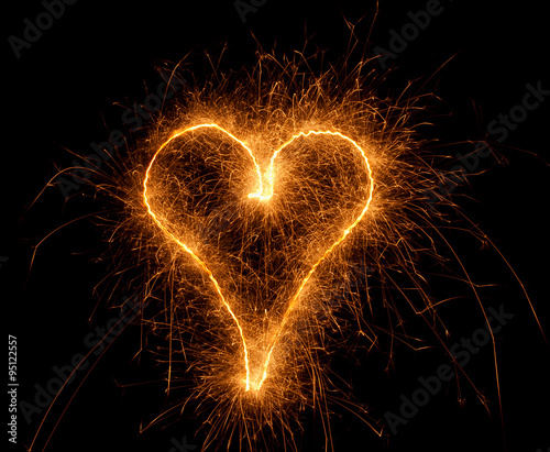 sparkler drawing heart on a black background