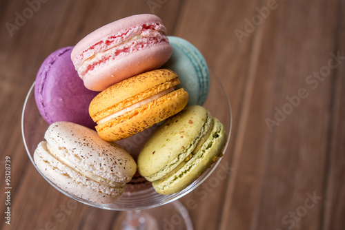 mix macaron in the martini glass on the wooden table 