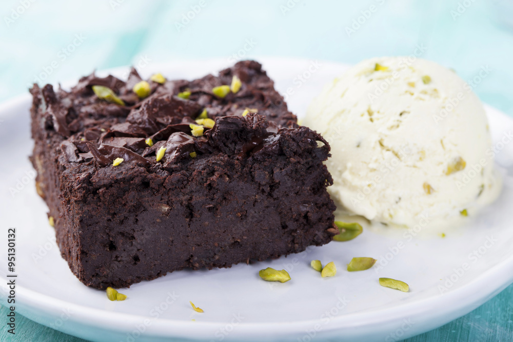 Chocolate brownie, cake, white plate on a turquoise wooden background Chocolate brownie, cake, white plate on a turquoise wooden background