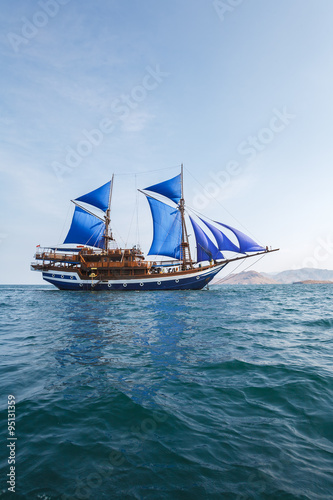 Vintage Wooden Ship with Blue Sails