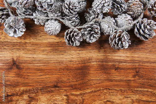 Rustic wood background with Christmas ornaments and pine cones