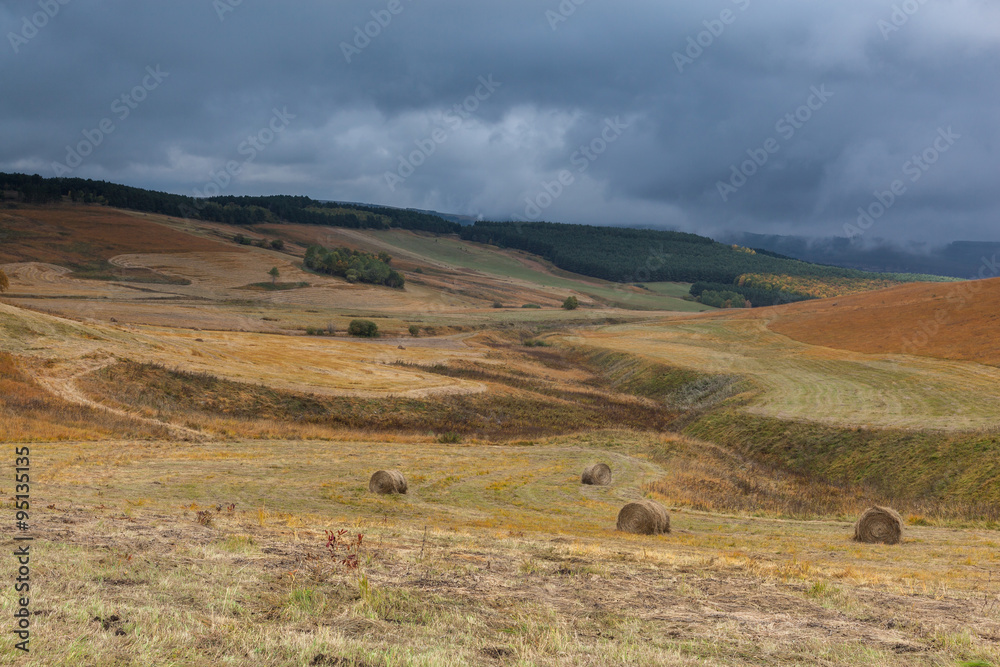 Storm clouds over the sloping meadows in the mountains.