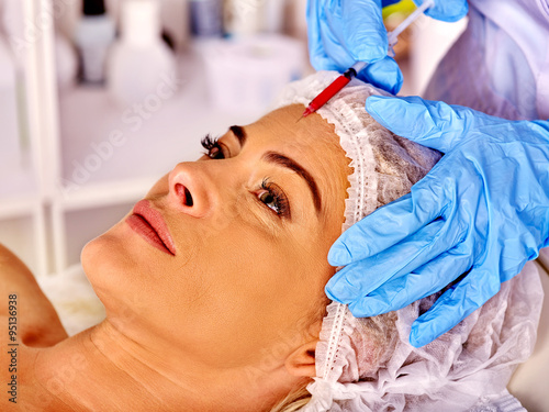 Middle-aged woman in spa receiving cosmetic injection