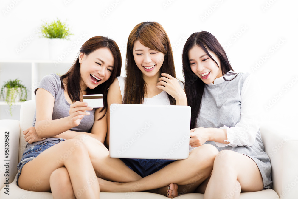 three young women watching laptop with on line shopping concept three young women watching laptop with on line shopping concept