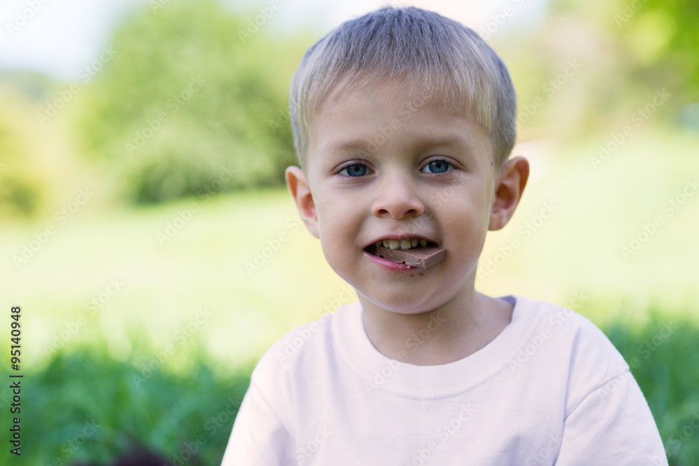 Joyful boy with chocolate in your mouth Joyful boy with chocolate in your mouth