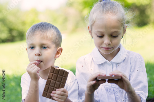 Boy and girl eating chocolate bar