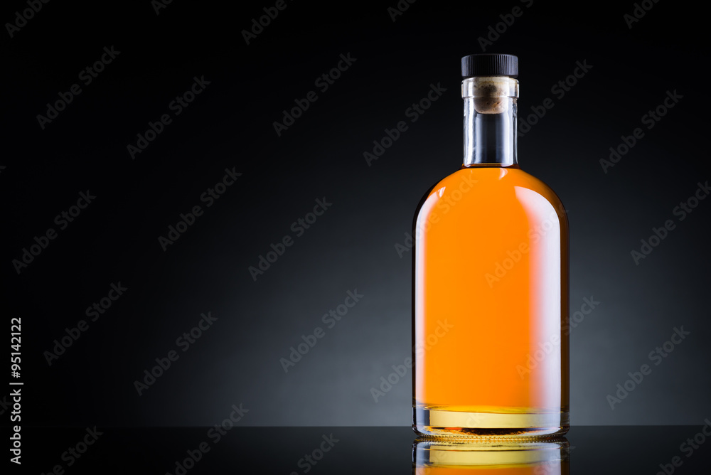 Whiskey bottle on black glass surface Whiskey bottle on black glass surface