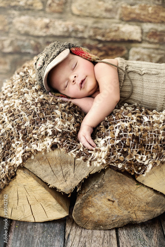 Little child sleepieng on the piece of wood photo