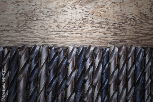 old rusty drill bits on wooden table