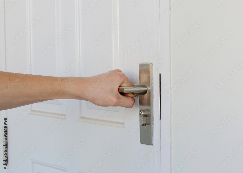 Fototapeta premium man's hand close the white door