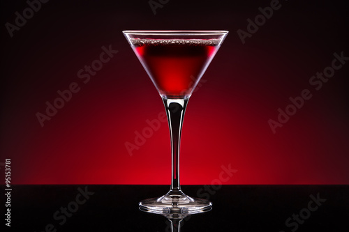 Cherry cocktail in a crystal glass isolated on red black backgro