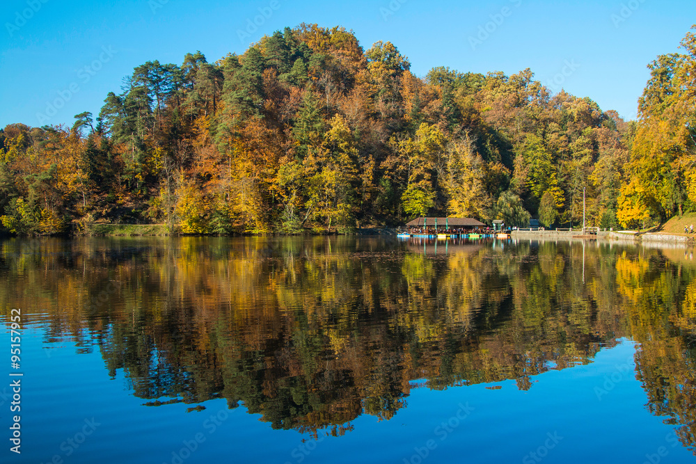 Boat floating on Trakoscan lake in Zagorje, Croatia, season, autumn, Reflection of trees on water Boat floating on Trakoscan lake in Zagorje, Croatia, season, autumn, Reflection of trees on water