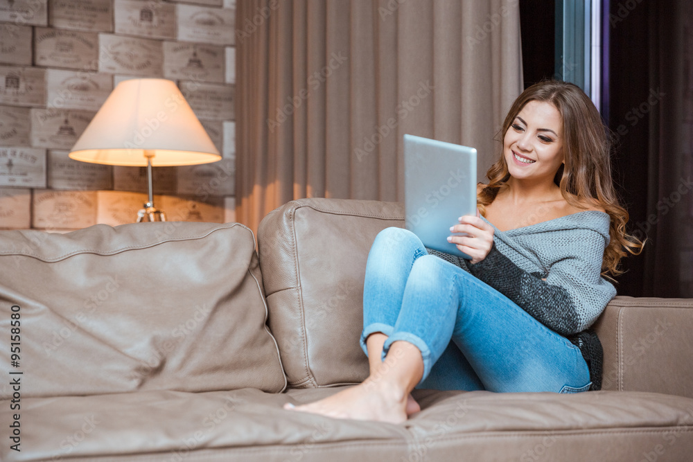Woman sitting on the couch with tablet computer Woman sitting on the couch with tablet computer