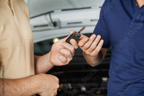 Client Giving Car Key To Mechanic