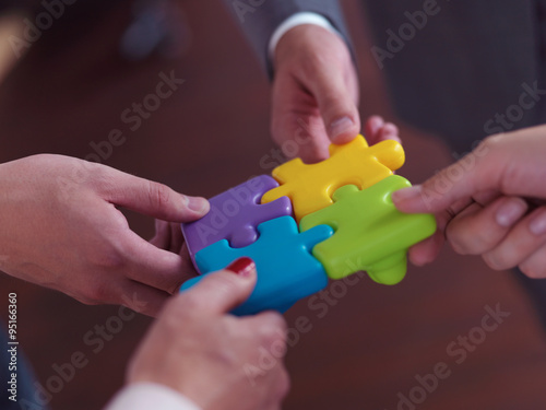 business people group assembling jigsaw puzzle