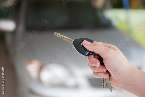women's hand presses on the remote control car alarm systems