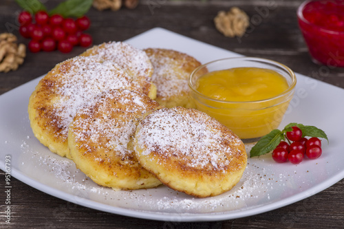 Delicious homemade cheese pancakes with honey  in white plate