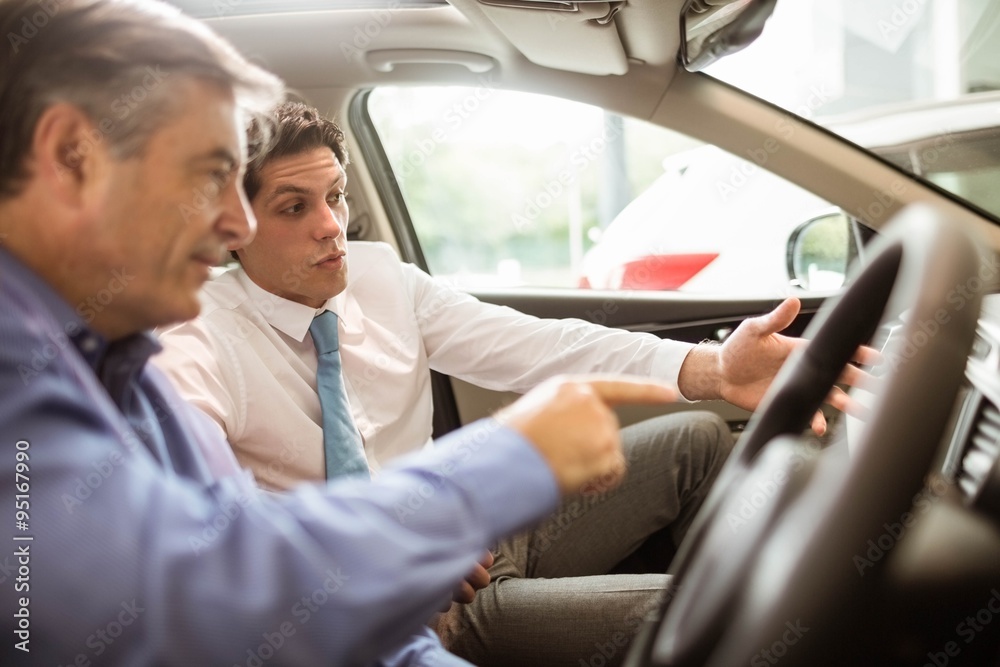 Businessman pointing a car interior Businessman pointing a car interior