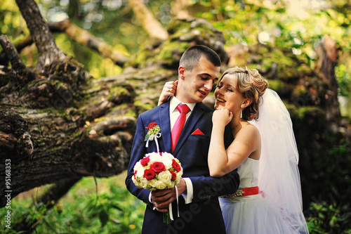 Young and gorgeus wedding couple on autumn forest