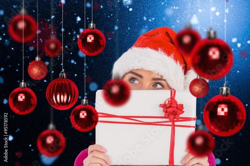 Composite image of festive blonde holding christmas gift photo