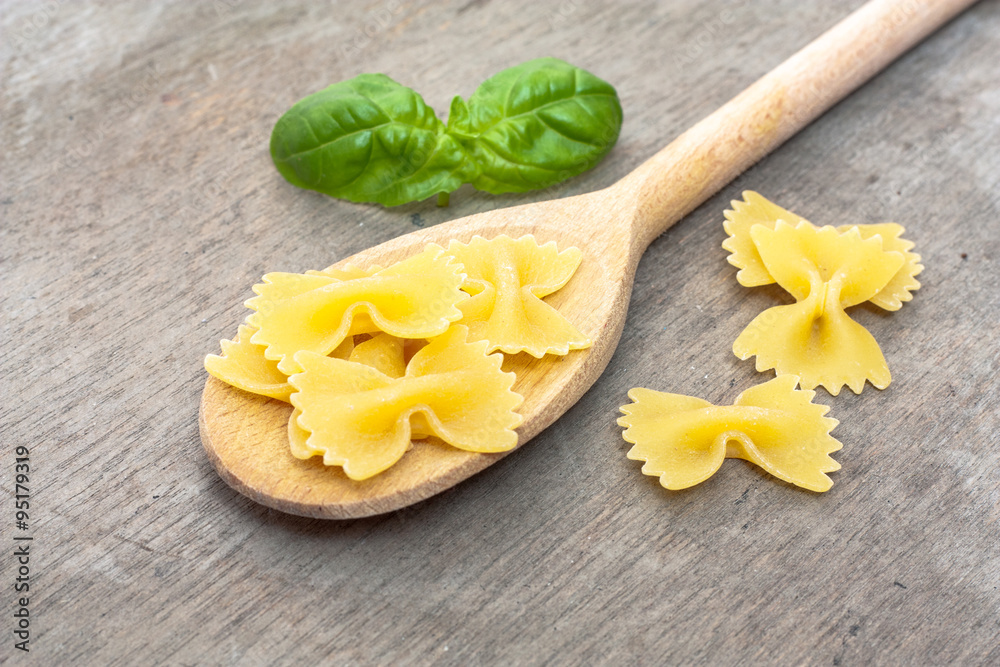 Fine farfalle noodles on wooden board Fine farfalle noodles on wooden board