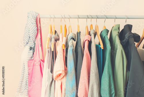 Pastel Color Female Clothes in a Row on Open Hanger. Toned photo