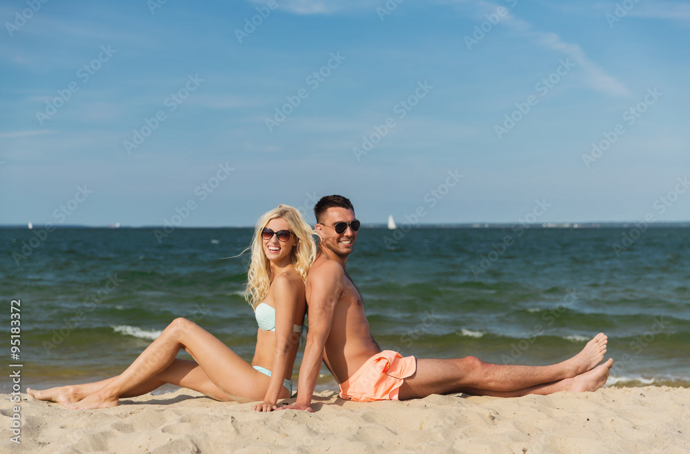 happy couple in swimwear sitting on summer beach happy couple in swimwear sitting on summer beach