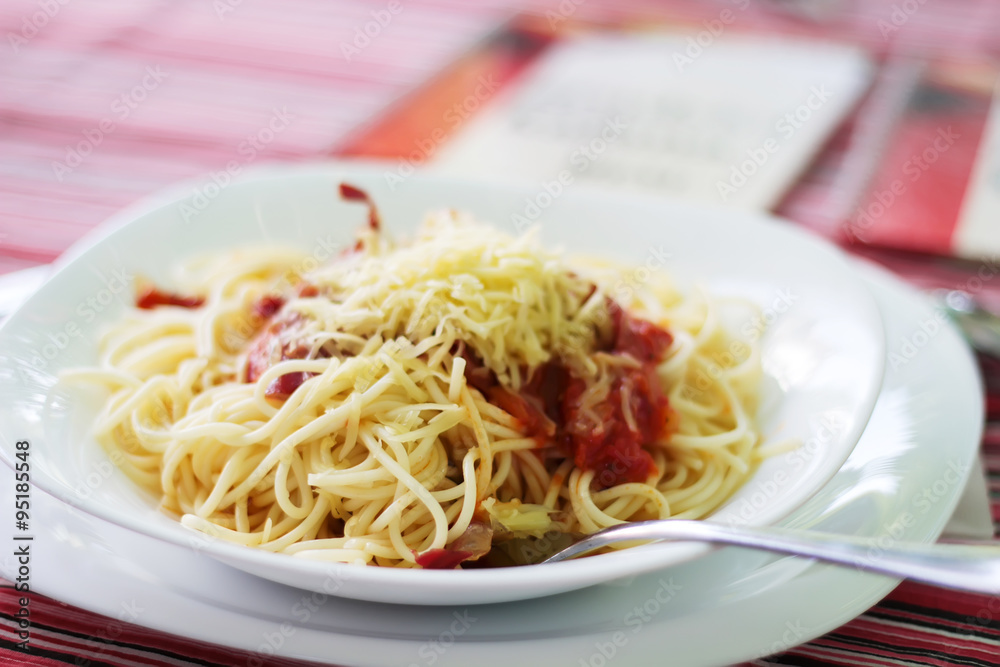 Spaghettis with cheese and ketchup on a white plate, selective focus Spaghettis with cheese and ketchup on a white plate, selective focus