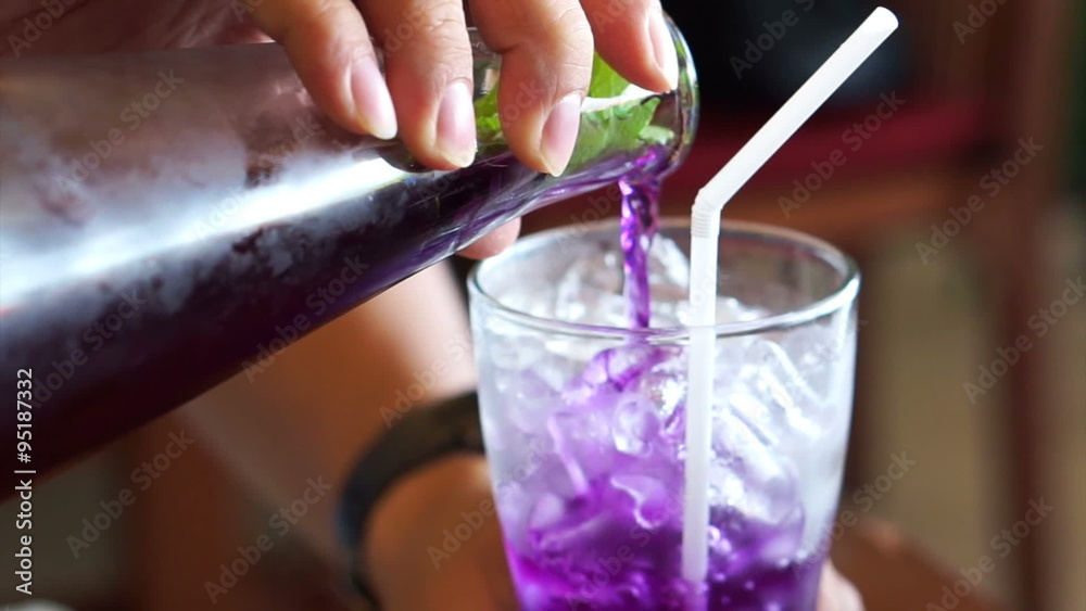 Herb drink, Butterfly pea, Clitoria ternatea L. flower mixed with lime, lemon being poured in to the glass