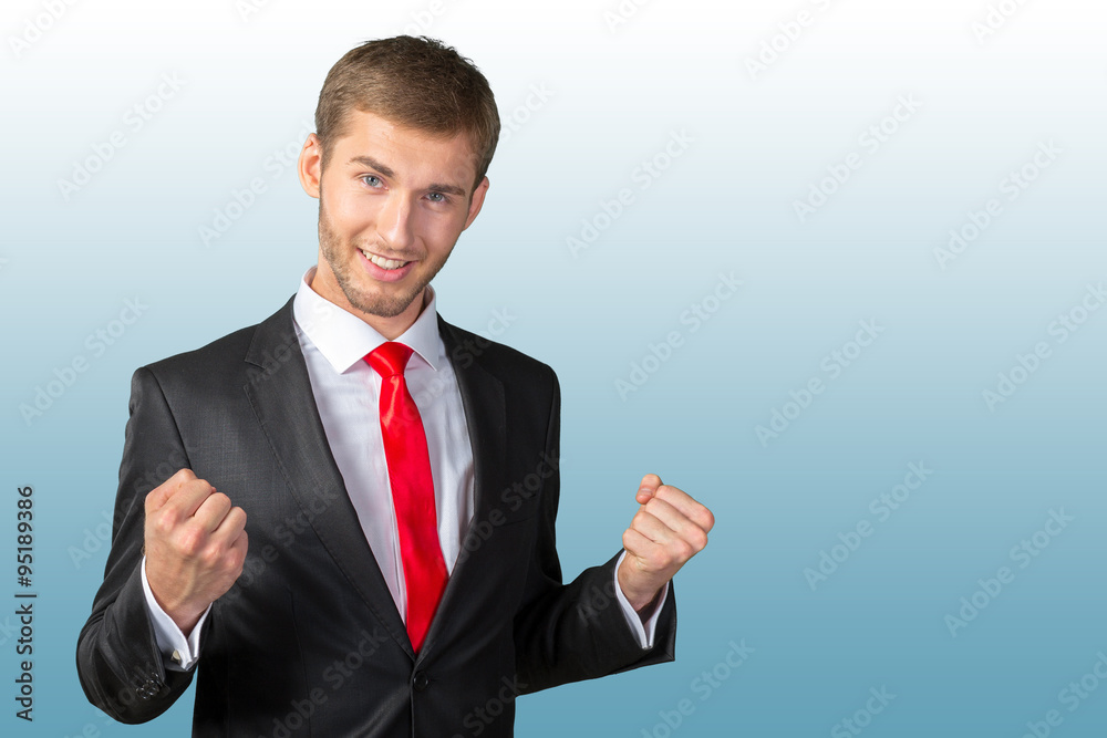 Successful young man celebrating with arms up