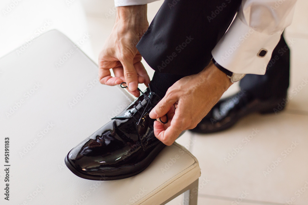 Groom tide he's shoes on a chair
