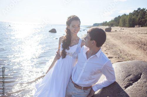 Just married happy bride and groom, young couple embraces on the beach © Ulia Koltyrina