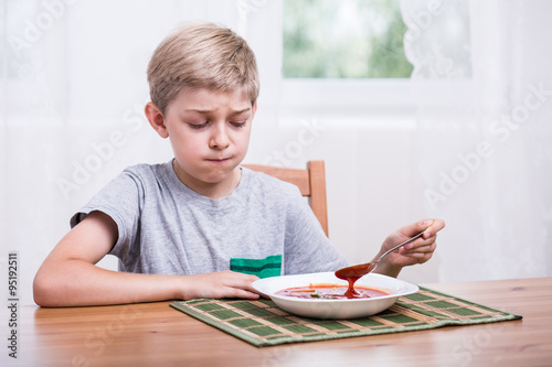 Fotografie Child eating soup with disgust