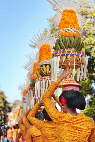 Procession of beautiful Balinese women in traditional costumes - sarong, carry offering on heads for Hindu ceremony. Arts festival, culture of Bali island and Indonesia people, Asian travel background photo