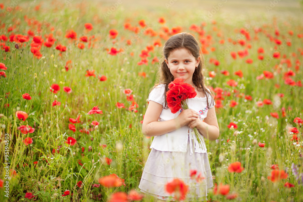 Cute girl in poppy field holding flowers bouquet outdoors. Girl in poppies. Happy kid with poppies. Cute girl in poppy field holding flowers bouquet outdoors. Girl in poppies. Happy kid with poppies.