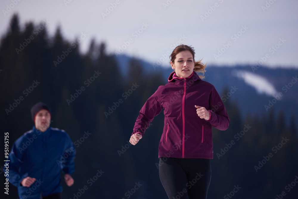 Fototapeta premium couple jogging outside on snow