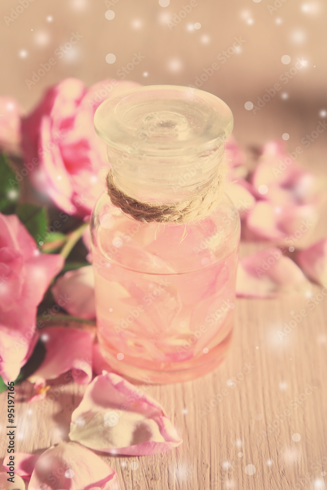 Rose oil in bottle on light background