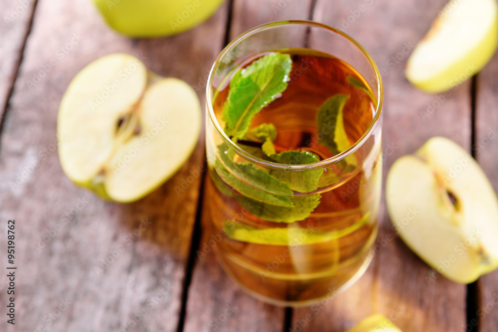 Glass of apple juice with fruits and fresh mint on table close up Glass of apple juice with fruits and fresh mint on table close up