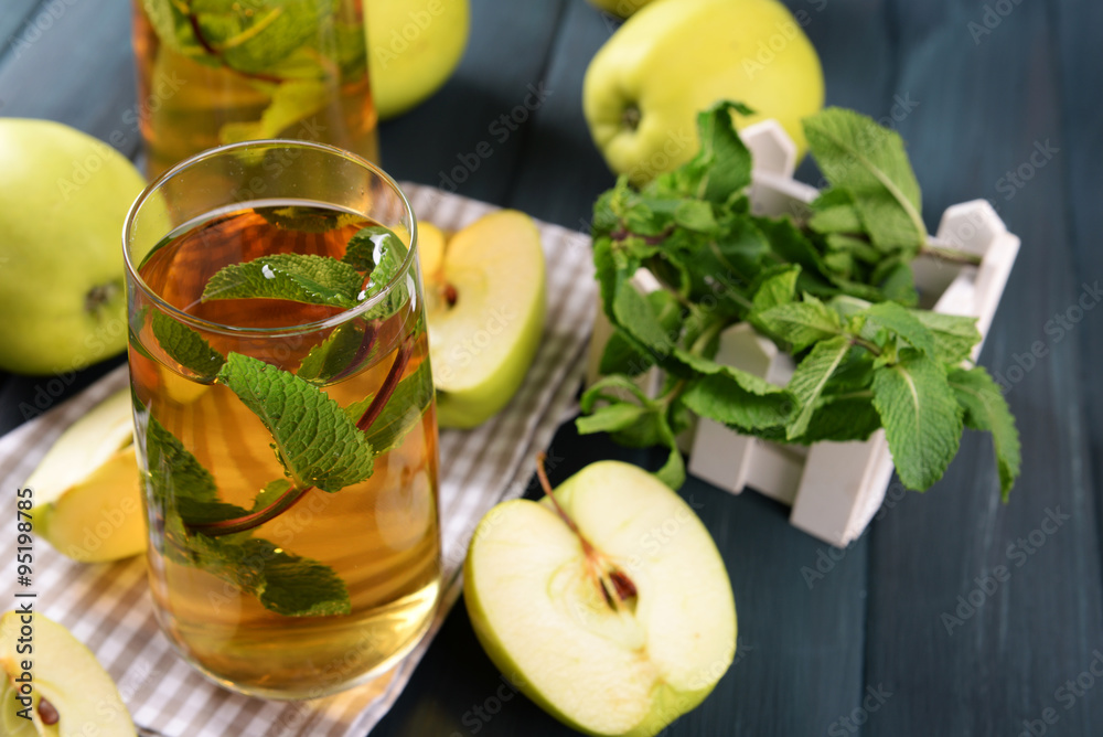 Glasses of apple juice with fruits and fresh mint on table close up Glasses of apple juice with fruits and fresh mint on table close up