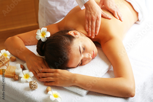 Young woman on massage table in beauty spa salon