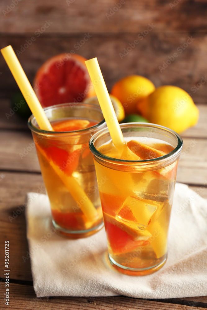 Fototapeta premium Iced tea with lemon and grapefruit on wooden background