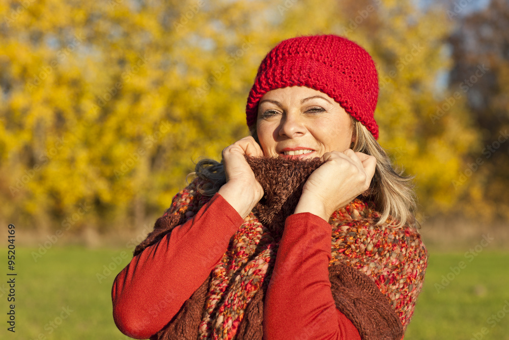 Glückliche Frau mittleren alters im Herbst draußen