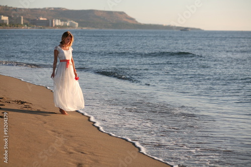 Девушка в белом платье на морском берегу