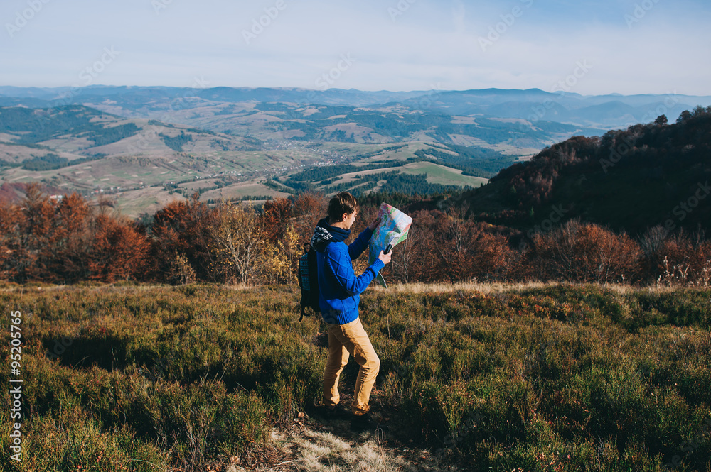 fellow tourist with map in hand and phone. autumn mountains