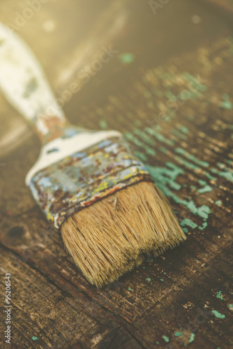 Old used paintbrush on rustic wooden board