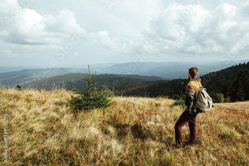 stylish beautiful traveling man hiking in the mountains on a bac © sonyachny