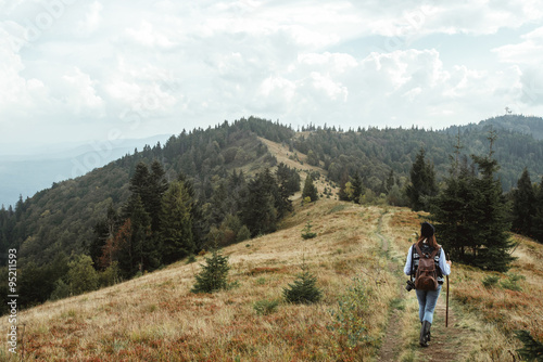 beautiful happy stylish traveling girl in the mountains on a bac